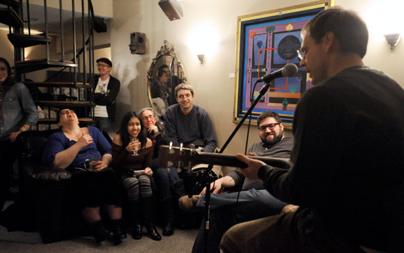 Marck Stanley, right, performs for Seltzer editor-in-chief Pete Cardamone, second from right, and others.